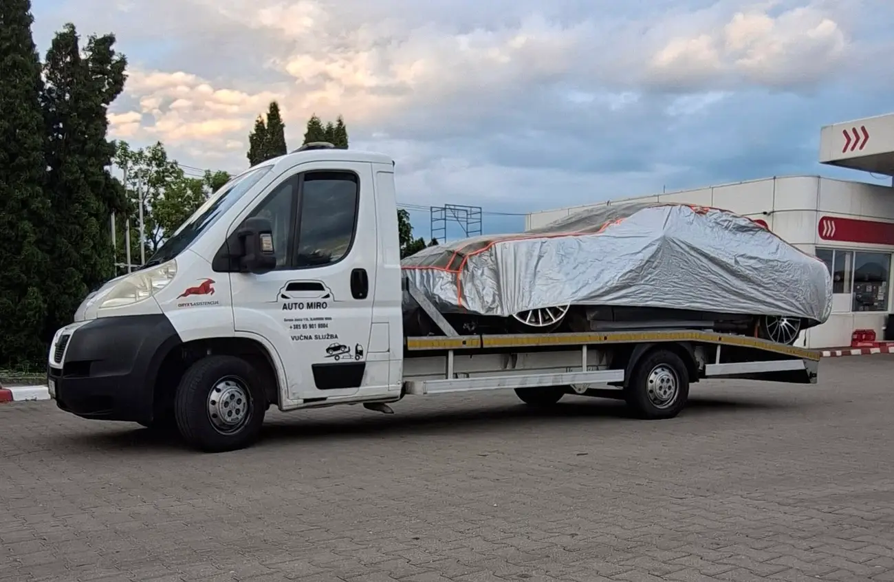 Kamion AUTO MIRO s automobilom pod zaštitnim pokrivačem na benzinskoj postaji